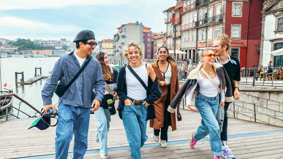 A group of young people strolling along a waterfront boardwalk