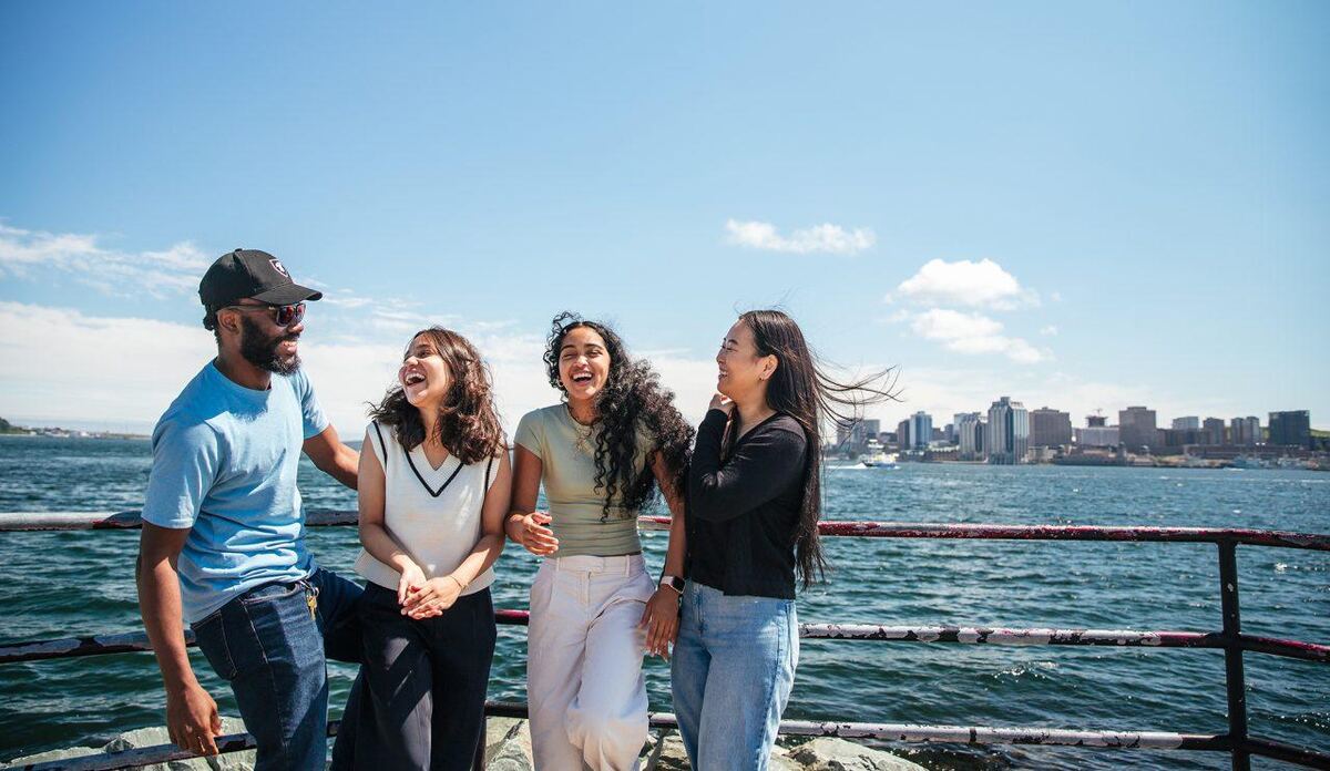 Friends laughing together on a seaside promenade